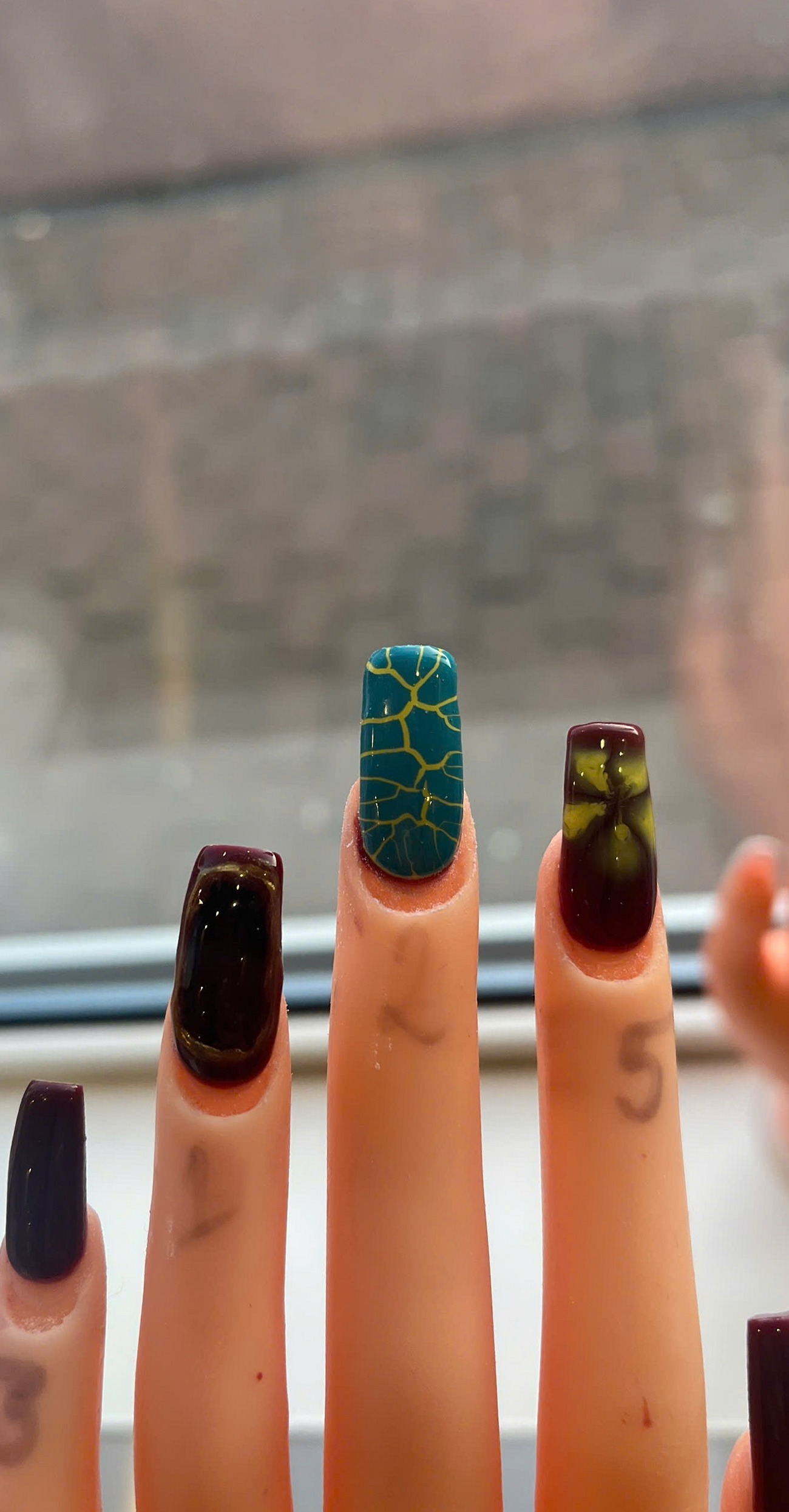 Oefenvingers met nail art in donkerrood, groen en goud